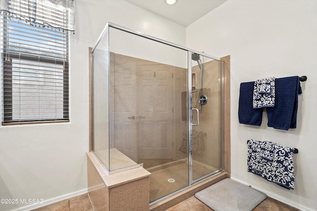 full bathroom featuring a shower stall and baseboards