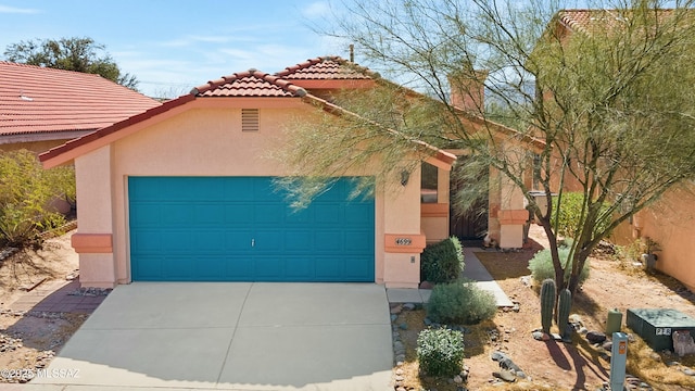 view of front facade with a tile roof, driveway, an attached garage, and stucco siding