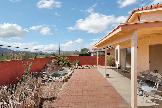 view of patio / terrace featuring fence private yard and a mountain view