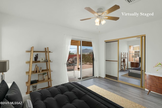 bedroom with access to outside, a closet, a ceiling fan, and wood finished floors