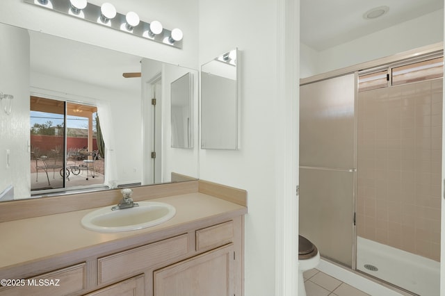 full bathroom with a stall shower, tile patterned flooring, vanity, and toilet