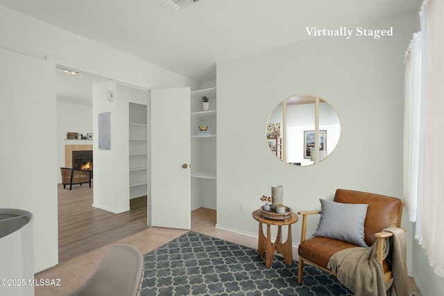 living area with a tile fireplace and tile patterned floors