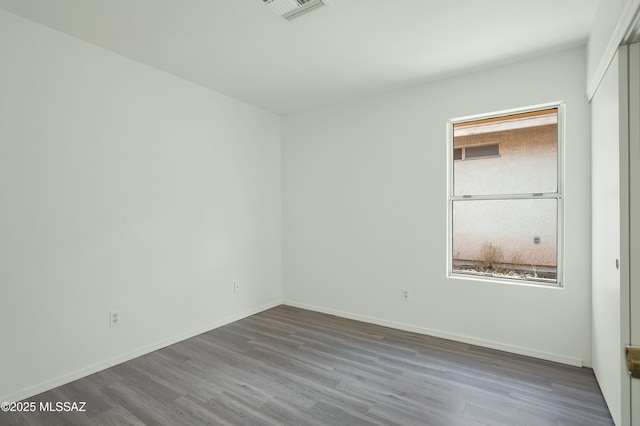 unfurnished bedroom with baseboards, visible vents, and wood finished floors