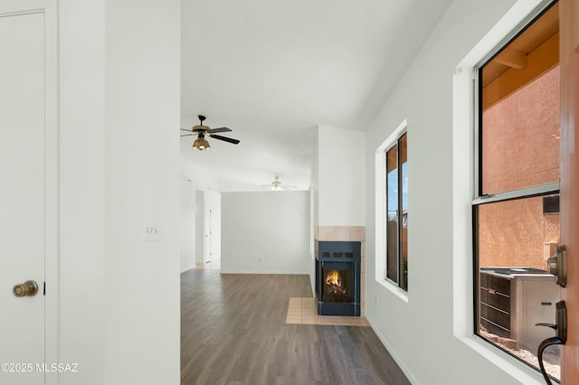 living room with baseboards, wood finished floors, and a tile fireplace