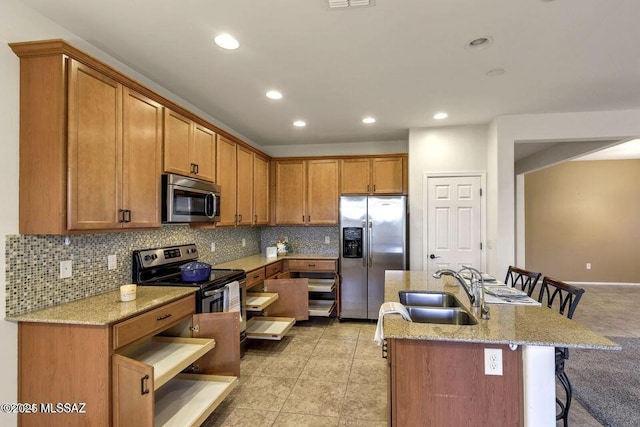 60579 E Flank Strap Dr, Tucson, AZ 85739 - kitchen featuring tasteful backsplash, appliances with stainless steel finishes, a kitchen breakfast bar, and a sink