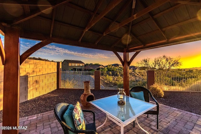 60579 E Flank Strap Dr, Tucson, AZ 85739 - patio terrace at dusk with a gazebo, fence, and outdoor dining space