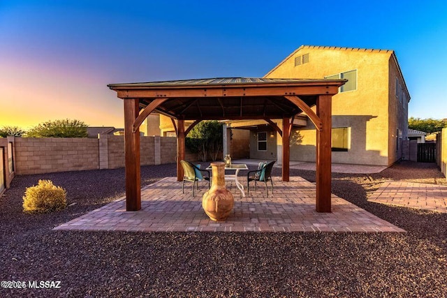 60579 E Flank Strap Dr, Tucson, AZ 85739 - patio terrace at dusk featuring a fenced backyard and a gazebo