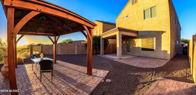 60579 E Flank Strap Dr, Tucson, AZ 85739 - patio terrace at dusk with a fenced backyard and a gazebo
