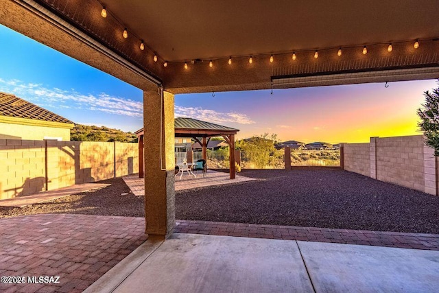 60579 E Flank Strap Dr, Tucson, AZ 85739 - patio terrace at dusk featuring a fenced backyard and a gazebo
