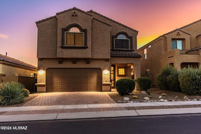 60579 E Flank Strap Dr, Tucson, AZ 85739 - mediterranean / spanish home with a garage, decorative driveway, a tiled roof, and stucco siding