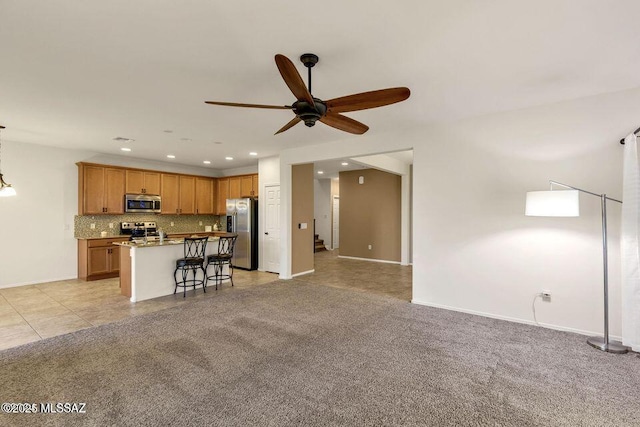 60579 E Flank Strap Dr, Tucson, AZ 85739 - kitchen featuring appliances with stainless steel finishes, open floor plan, light carpet, and tasteful backsplash