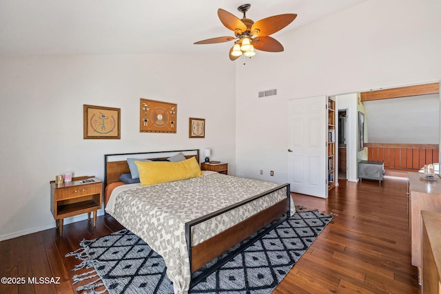 bedroom featuring visible vents, high vaulted ceiling, baseboards, and hardwood / wood-style floors