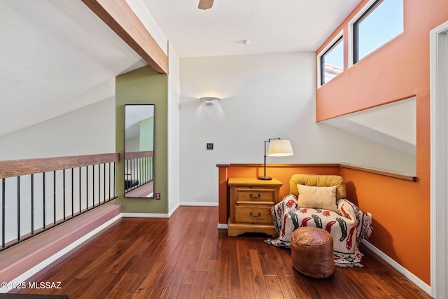 sitting room with vaulted ceiling with beams, baseboards, and wood-type flooring