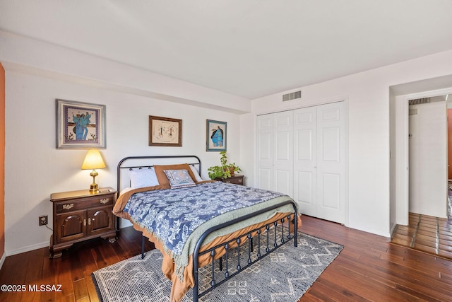 bedroom featuring visible vents, baseboards, a closet, and dark wood-style flooring