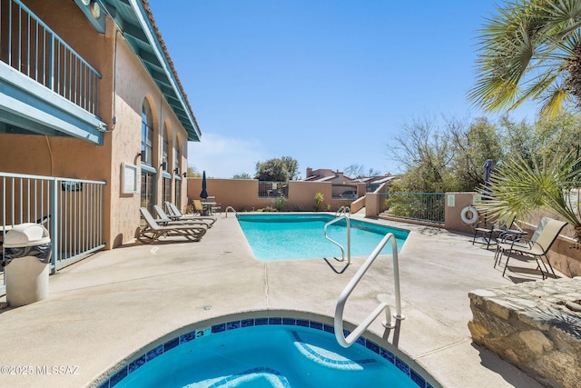 pool featuring a patio, fence, and a hot tub