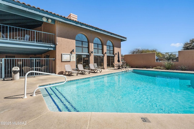 pool featuring a patio and fence