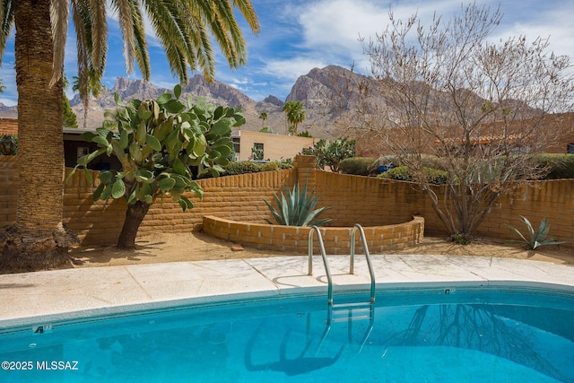 view of swimming pool with fence, a mountain view, and a fenced in pool