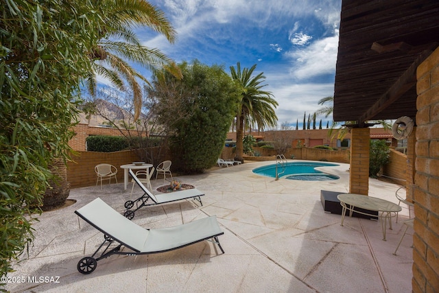 view of swimming pool featuring an outdoor fire pit, a fenced in pool, a fenced backyard, and a patio