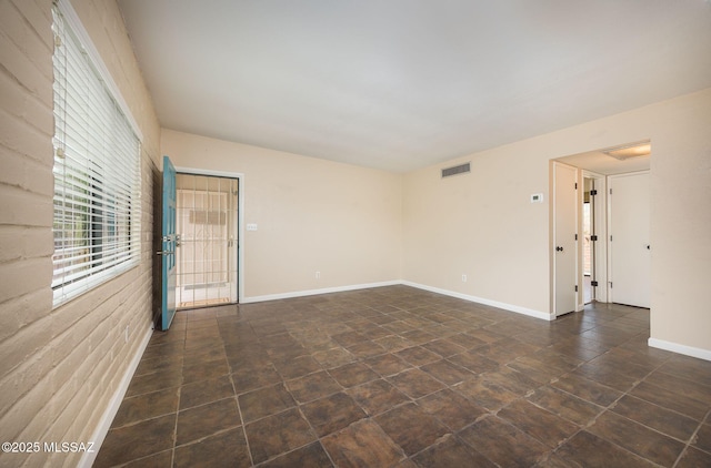 unfurnished room featuring baseboards and visible vents