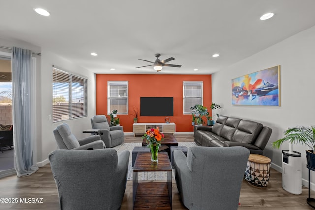 living area featuring baseboards, wood finished floors, a ceiling fan, and recessed lighting