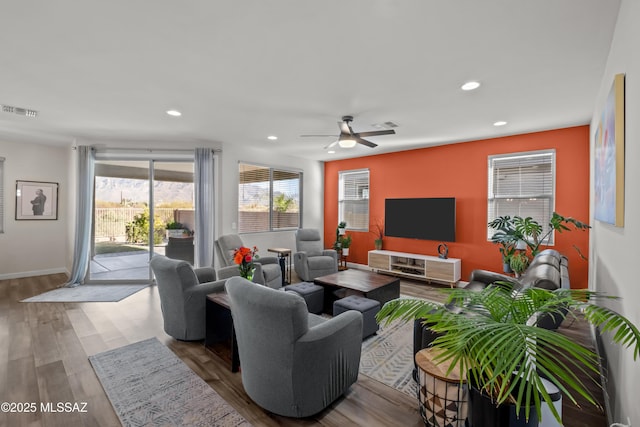 living area featuring baseboards, wood finished floors, visible vents, and recessed lighting