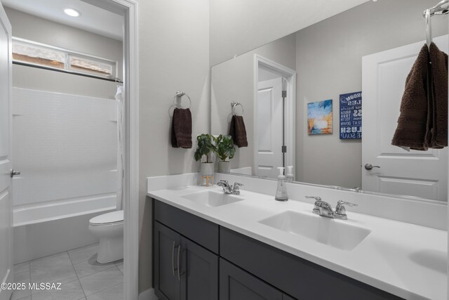 bathroom featuring double vanity, a sink, toilet, and tile patterned floors