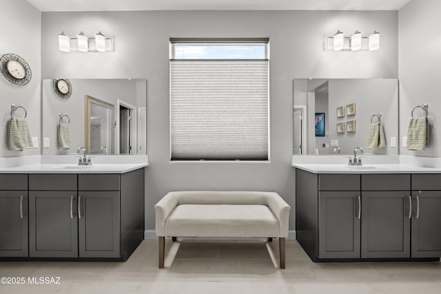 bathroom with two vanities, a sink, and baseboards