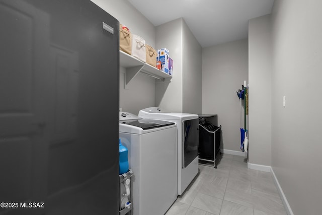 laundry room with laundry area, baseboards, and washer and clothes dryer