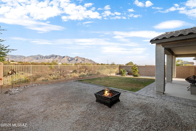 view of yard with a fire pit, a patio, a fenced backyard, and a mountain view