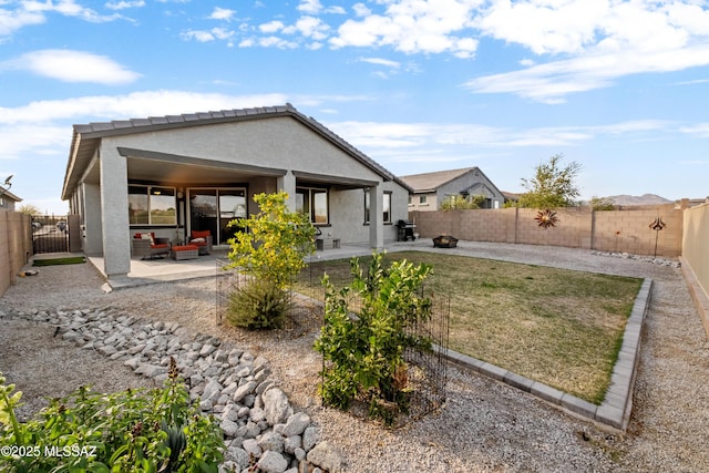 back of property with a tile roof, a fenced backyard, a patio, and stucco siding