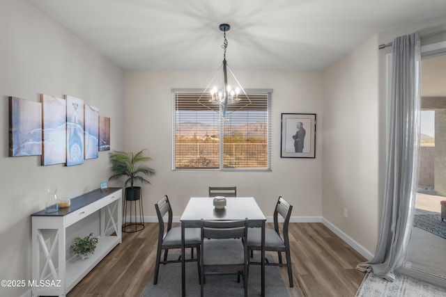 dining room featuring a chandelier, wood finished floors, and a healthy amount of sunlight