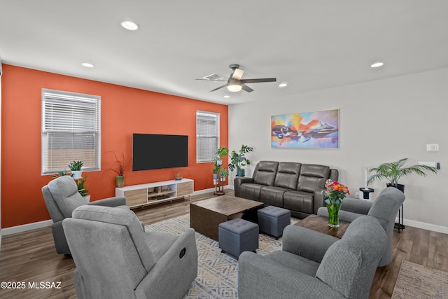 living room featuring recessed lighting, a healthy amount of sunlight, baseboards, and wood finished floors