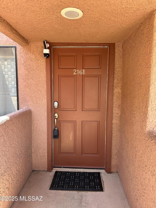 entrance to property featuring stucco siding