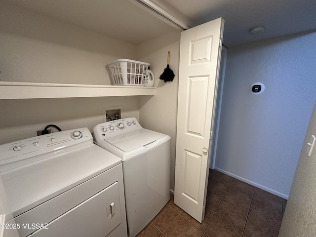 laundry area featuring washer and dryer, laundry area, and dark tile patterned flooring