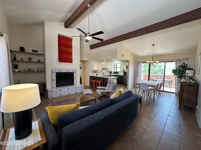 tiled living room featuring high vaulted ceiling, ceiling fan with notable chandelier, a fireplace, a sink, and beam ceiling