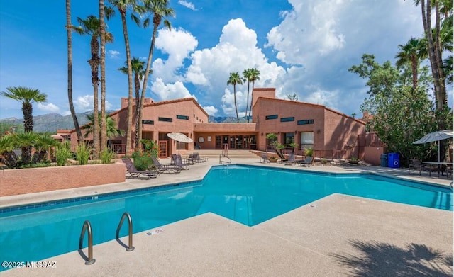 pool with a patio area and fence