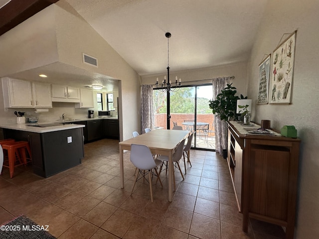 tiled dining area featuring a chandelier, visible vents, vaulted ceiling, and a sink