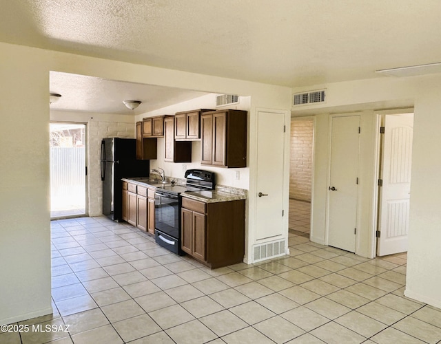 kitchen featuring a sink, visible vents, a textured ceiling, and black appliances