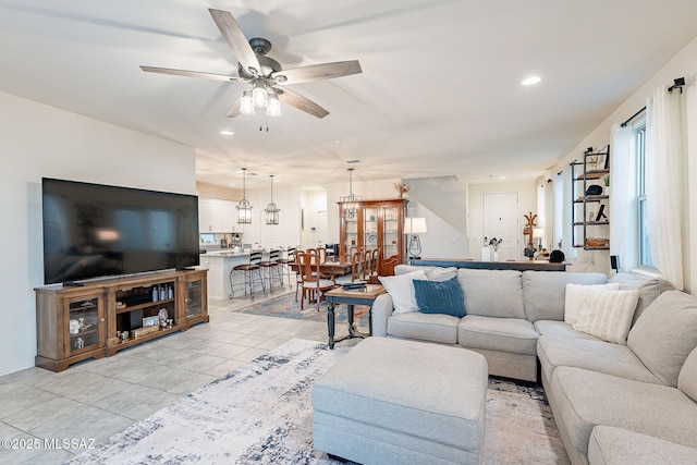 living area featuring light tile patterned flooring, a ceiling fan, and recessed lighting