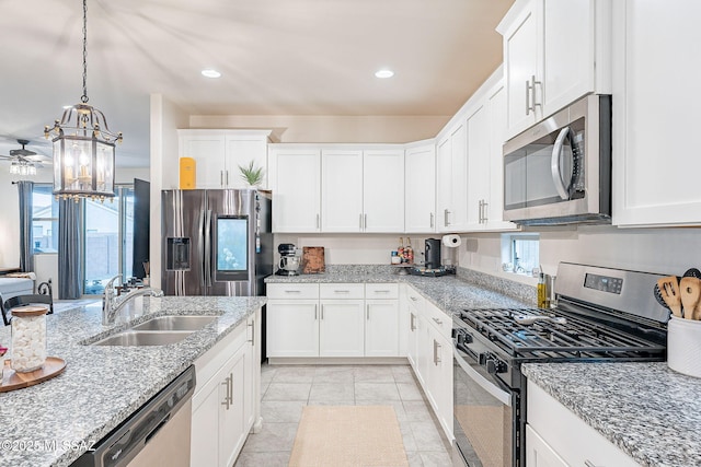 kitchen featuring appliances with stainless steel finishes, a healthy amount of sunlight, white cabinetry, and a sink