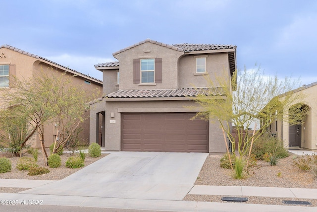 mediterranean / spanish-style home featuring driveway, a tile roof, a garage, and stucco siding