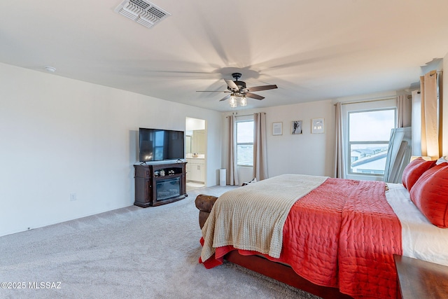 bedroom with carpet floors, visible vents, ceiling fan, and multiple windows