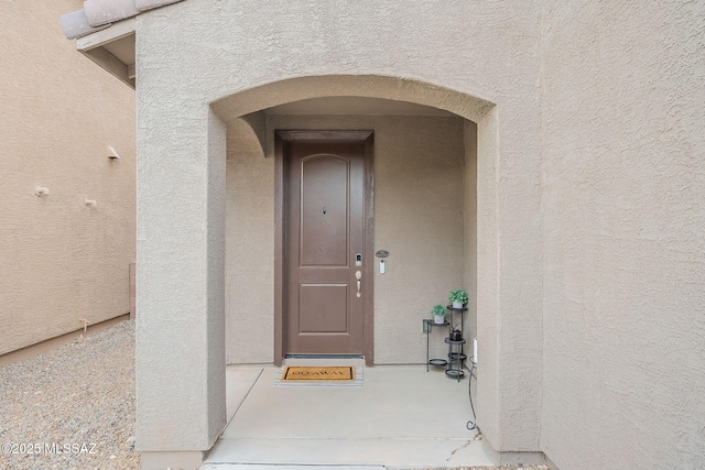 doorway to property featuring stucco siding