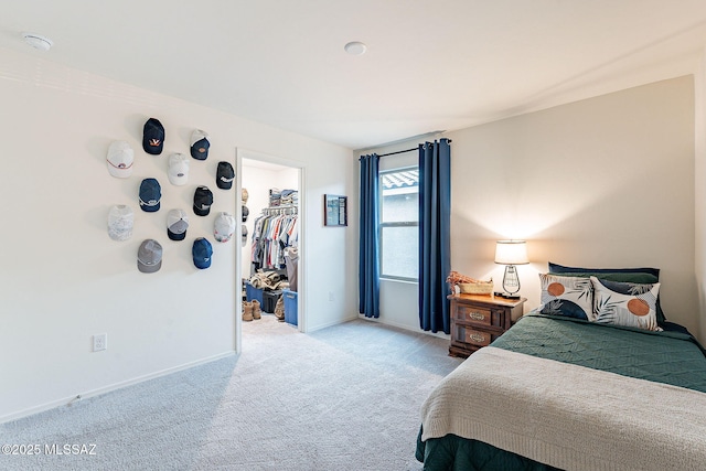 bedroom with carpet floors, baseboards, a walk in closet, and a closet