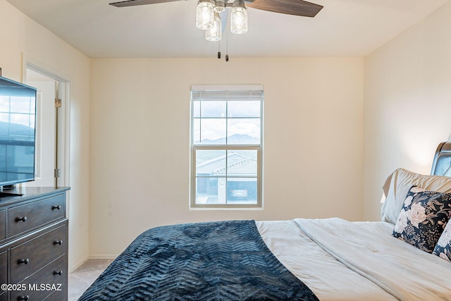 bedroom featuring light carpet, ceiling fan, and baseboards