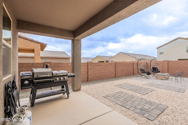 view of patio featuring a fenced backyard, a fire pit, and area for grilling