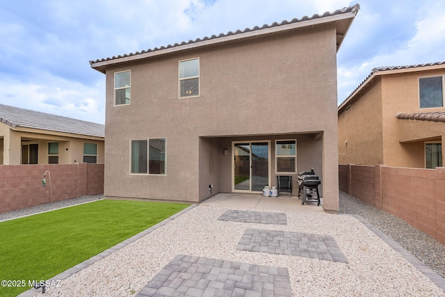 back of property with a patio area, a fenced backyard, a lawn, and stucco siding