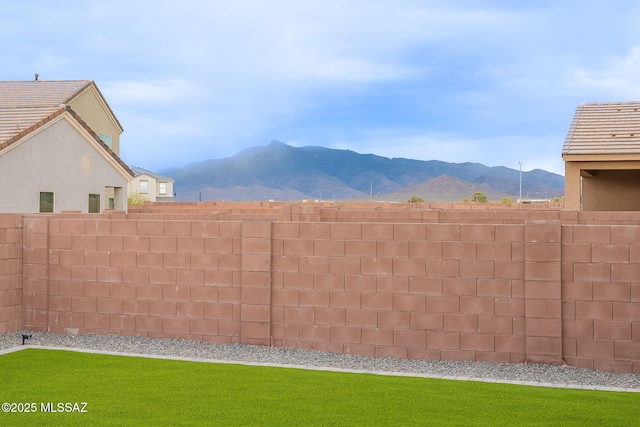 view of yard with fence and a mountain view