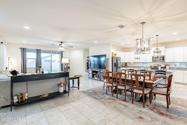 dining space featuring light tile patterned floors, recessed lighting, visible vents, and ceiling fan with notable chandelier