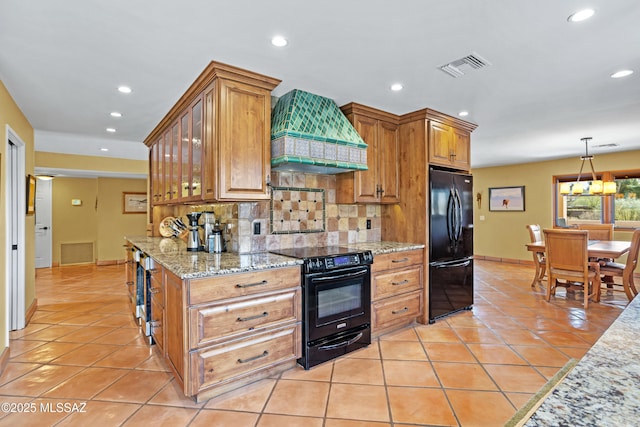 kitchen with light tile patterned floors, visible vents, custom exhaust hood, black appliances, and tasteful backsplash